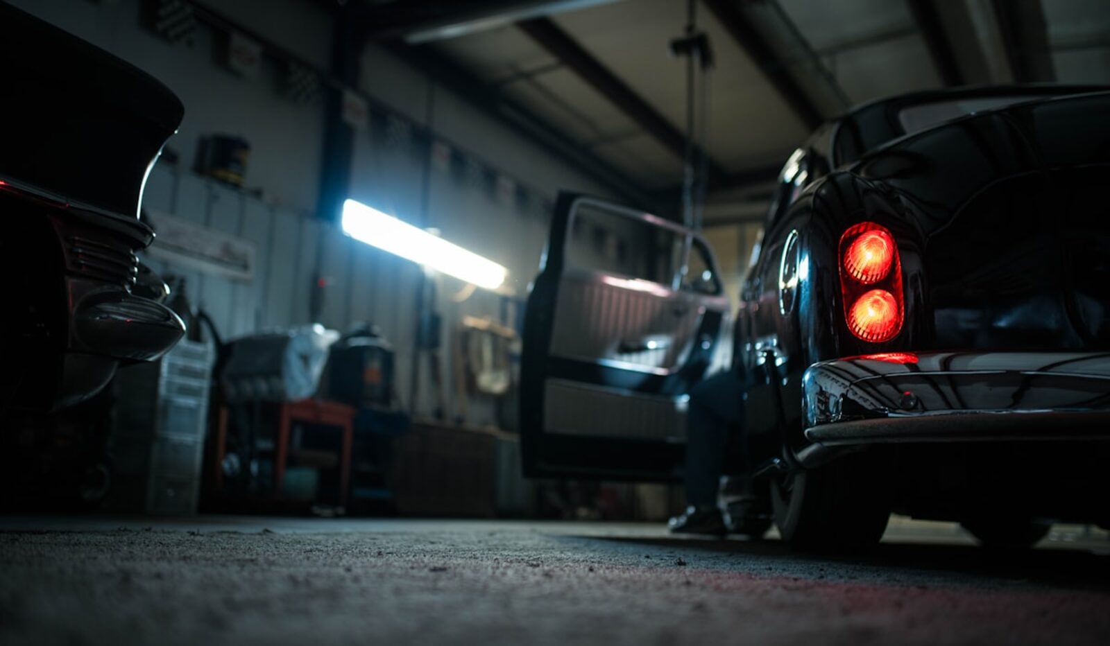 The Arbor shop floor after hours, warm light over a vehicle in for repair