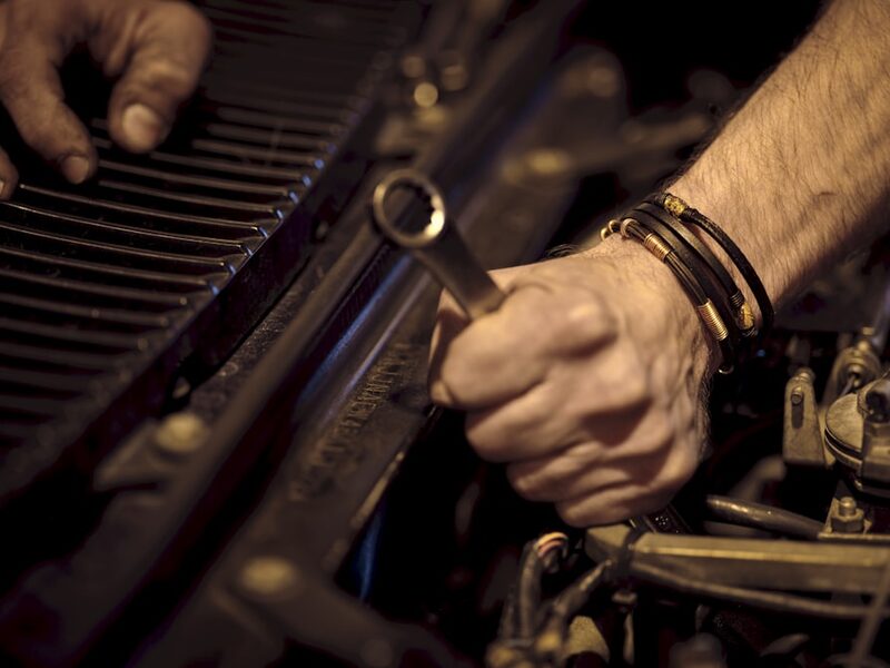Close hands-on repair work under warm shop light